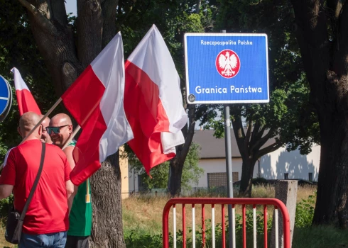 Cilvēki piedalās piketā, lai iebilstu pret migrantu atgriešanu, Polijas dienvidrietumos, 2025. gada 3. jūlijā.