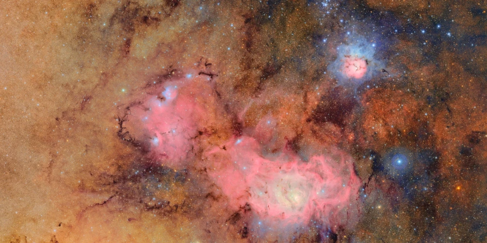 Ar Veras Rubinas teleskopu uzņemtais pirmais attēls – septiņās stundās uzņemti 678 kadri, kas apvienoti vienā un ataino citādi blāvas vai neredzamas detaļas, piemēram, gāzu un putekļu mākoņus, kas veido Trīsdaļu miglāju (augšējā labajā stūrī) un Lagūnas miglāju vairākus tūkstošus gaismas gadu no Zemes.