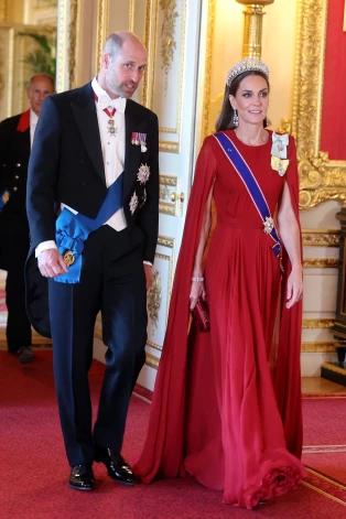 Svinīgo banketu Ketrīna apmeklēja sarkanā vakarkleitā, ko izstrādājusi angļu dizainere Sāra Bērtone franču modes namam “Givenchy”.