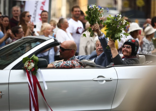 Rīdzinieki un pilsētas viesi sveic XIII Skolu jaunatnes dziesmu un deju svētku dalībniekus gājienā.