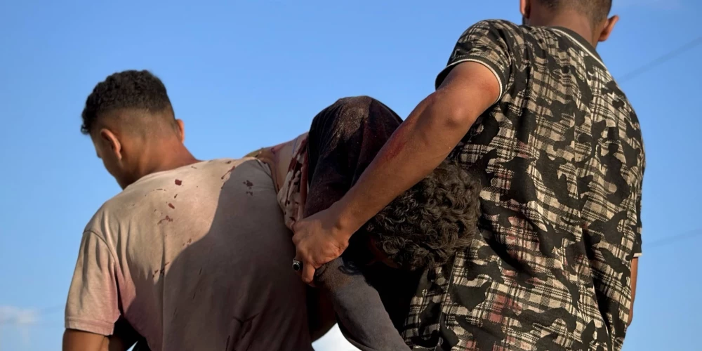 Ievainotie palestīnieši tiek nogādāti slimnīcā. 