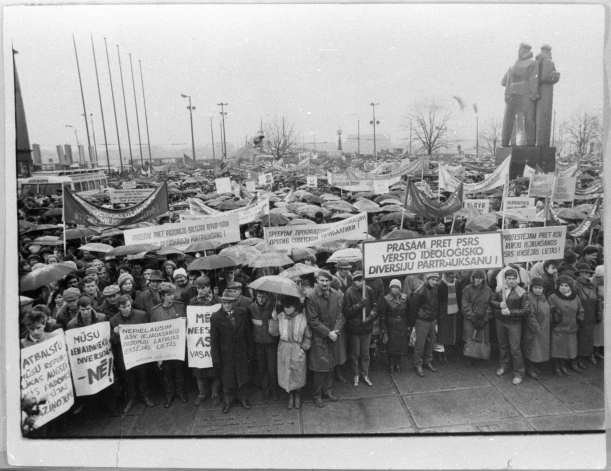 Jau Gorbačova "perestroikas" laikā, 1987. gada novembrī, komunisti Rīgā sarīkoja mītiņu, kurā "darbaļaudis nosodīja kapitālistisko valstu iejaukšanos PSRS iekšējās lietās un naidīgo radiobalsu propagandu". Mītiņš bija organizēts kā atbildes gājiens pret pirmajiem mēģinājumiem 18. novembrī nolikt ziedus pie Brīvības pieminekļa. (Foto: Valsts Kinofotofonodokumentu arhīvs / Leonīds Pantuss, V. Bērziņš, V. Ivanovskis, J. Jasenovs)