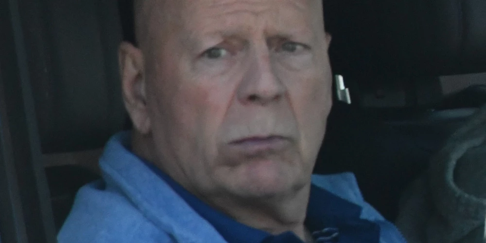 Брюс Уиллис передвигается на машине с сопровождающими.