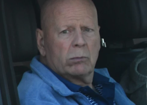 Брюс Уиллис передвигается на машине с сопровождающими.