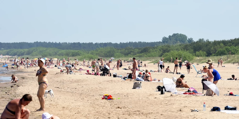 Cilvēki atpūšas Vecāķu pludmalē.