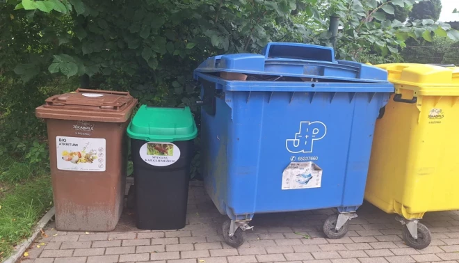Mazais melnais atkritumu konteiners Jēkabpilī, kurš iespiests starp “lielajiem brāļiem”, paredzēts tikai un vienīgi nogalētiem Spānijas kailgliemežiem.
