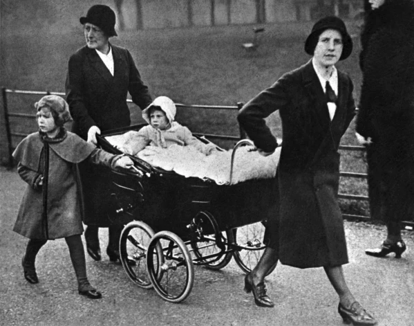 Юная Елизавета (слева) прогуливается со своей младшей сестрой принцессой Маргарет и нянями.