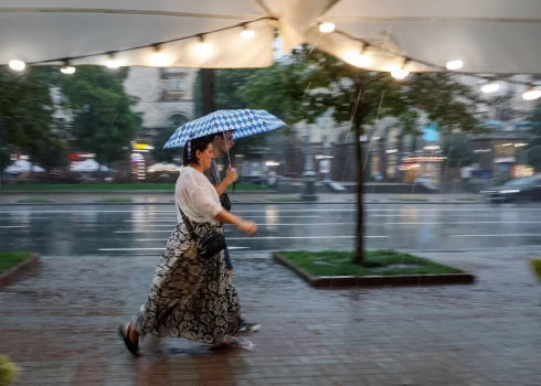 Cilvēki Kijivas centrā spēcīga lietus laikā 2025. gada 6. augustā.