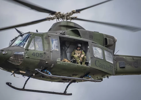 Канадский вертолет Griffon обеспечивает воздушное прикрытие, в то время как Chinook тактически доставляет гаубицу M777 на полигоне Azadi в Латвии 22 июля 2025 года. 