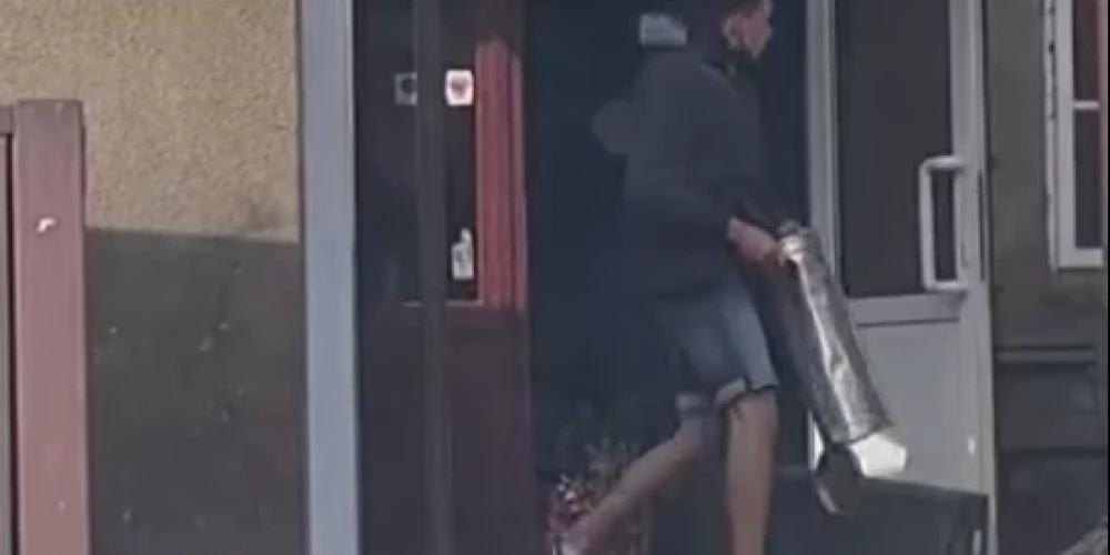 Vīrietis ar miskasti izsit krogam „Varde” logus.