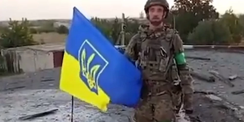425. triecienpulka "Skala" kaujinieki paceļ Ukrainas karogu virs skolas Udačnes rietumu daļā.