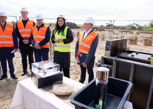 Министр земледелия Армандс Краузе (слева), министр экономики Викторс Валайнис, председатель самоуправления Елгавы Андрис Равиньш, председатель правления AS Rietumu banka Елена Бурая и член правления SIA ASNS Ingredient Эдгарс Ружа участвуют в торжественной церемонии закладки капсулы с посланием на строительстве завода по производству горохового протеина SIA ASNS Ingredient в Елгаве в апреле 2025 года.