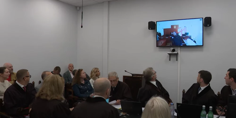 Tiesas sēde notika nelielā zālē, kurā pie galda nebija vietas visiem advokātiem (ekrānuzņēmums no video)