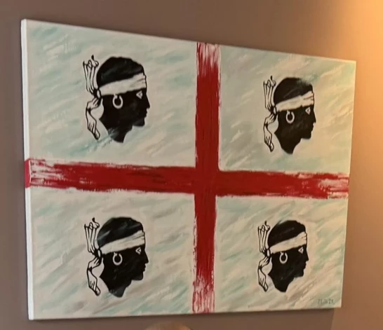 Par Sardīnijas karoga izcelsmi versijas ir dažādas. Viena no tām ir visai skarba – senatnē, kaujās uzvarot afrikāņus, Sardīnijas galvaspilsētas Kaljāri aizstāvji par brīdinājumu iekarotājiem uzsprauduši uz mietiem četras moru galvas. Tikai šajā gadsimtā no viņu acīm noņemts apsējs. Kādreiz latvieši par moriem sauca afrikāņus, bet par mauriem – Ziemeļāfrikas musulmaņus.