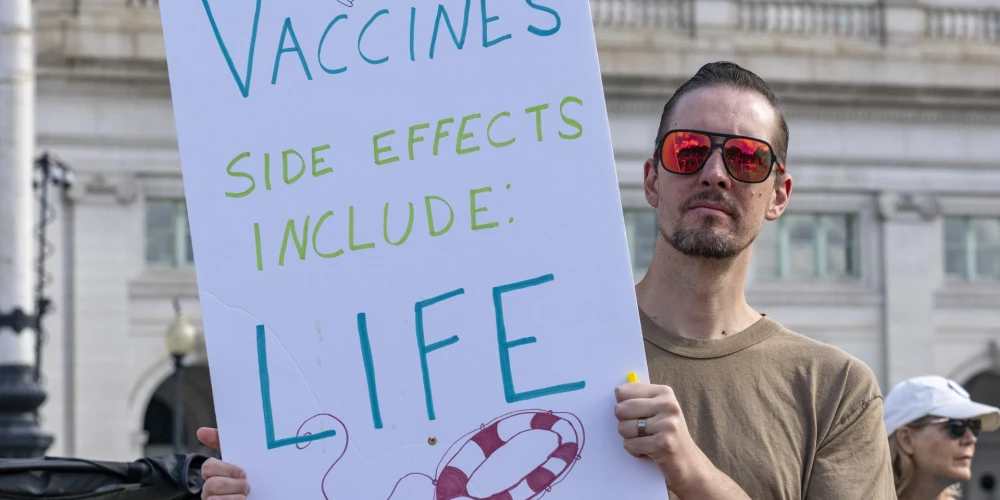 Vakcīnu blakne ietver dzīvību, atgādina protestētājs Vašingtonā. Pēdējos 50 gados vakcinācija izglābusi vismaz 154 miljonus dzīvību, pārsvarā zīdaiņus.