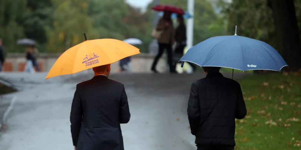 Vīrieši ar lietussargiem Bastejkalnā.
