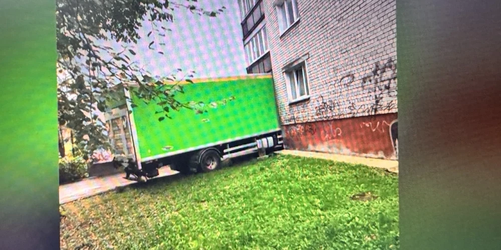 Зелёный фургон застрял и повредил фасад дома.