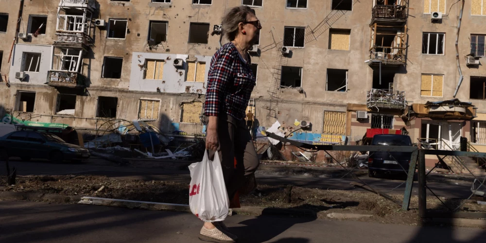 Люди ходят среди поврежденных жилых домов после российского удара в Краматорске, Донецкая область.