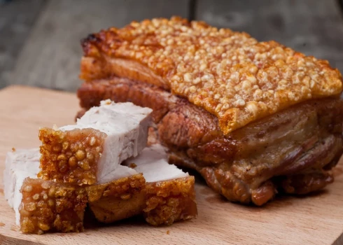 Lēni cepta cūkas pavēdere ar zaļumu mērcīti