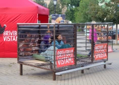 Pie Saeimas cilvēki sēž sprostā, parādot dējējvistu necilvēcīgos uzturēšanas apstākļus. VIDEO, FOTO
