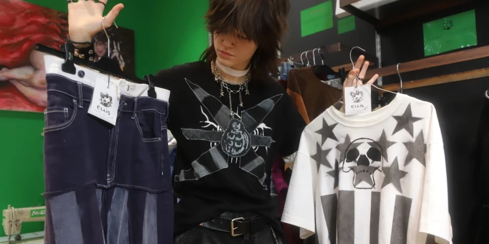 Ellis demonstrē zilās džinsa bikses, kas tika šūtas, izmantojot auduma manipulācijas tehniku. Kreisajā rokā viņš tur kreklu. Iedvesma grupa "The Prodigy".