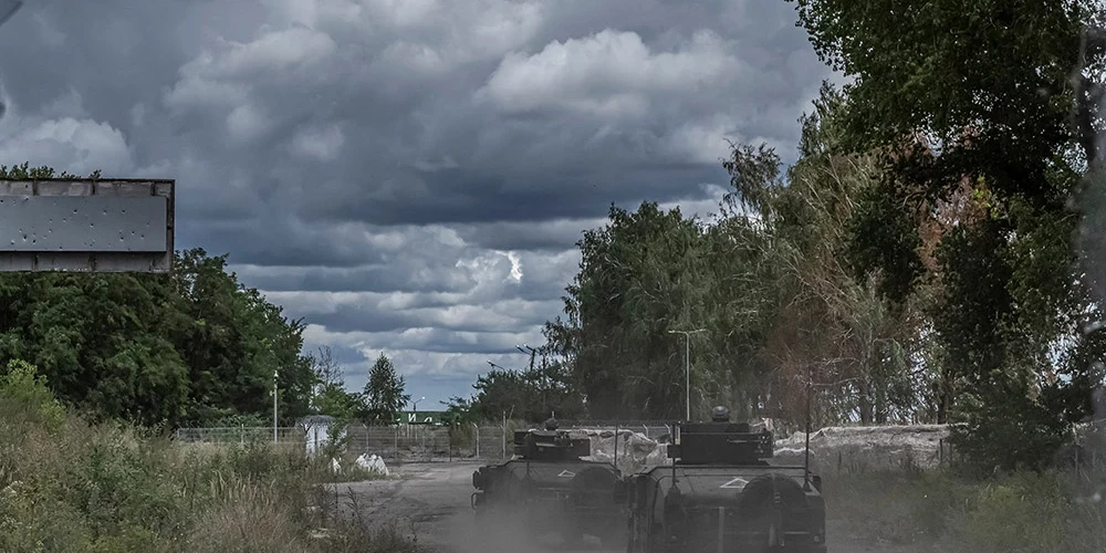 Ukrainas karavīri Sumu apgabalā brauc ar militārajiem transportlīdzekļiem robežšķērsošanas punktā ar Krieviju.