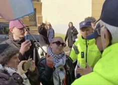 Likumsargi pie Saeimas vēršas pret kādu demonstranti ar izķēzītu Latvijas karogu rokās. VIDEO