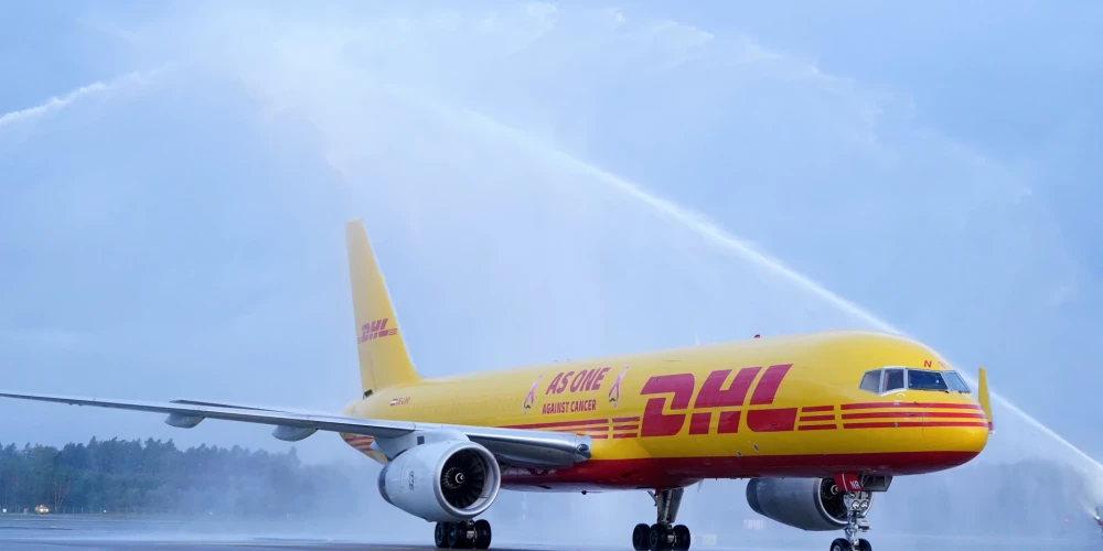 Rīgas lidostā notiek pasākums, kurā sagaida krūts vēža pacientu atbalstīšanai dizainētu loģistikas uzņēmuma "DHL" lidmašīnu.
