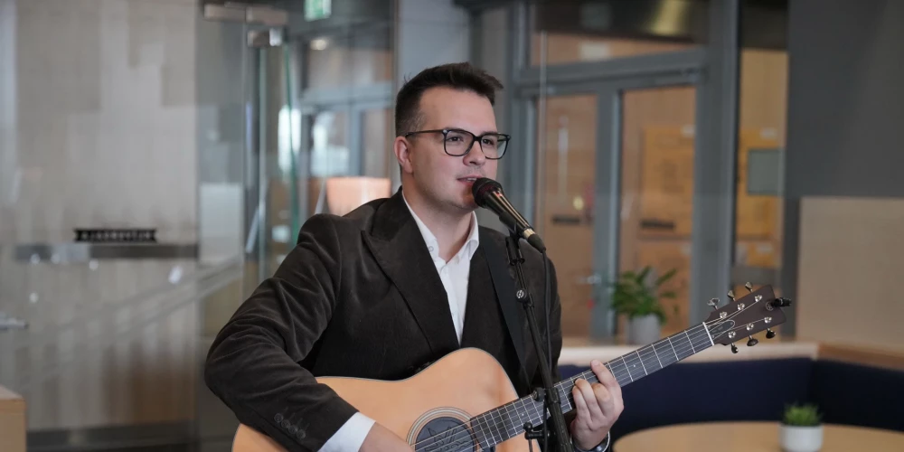 Kamēr Mārtiņš sniedza muzikālo priekšnesumu savas dzejas grāmatas atklāšanā, sieva Žanete viņu vēroja ar mīlestības pilnu skatienu.