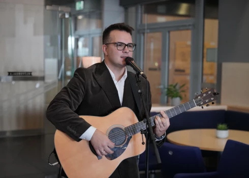 Kamēr Mārtiņš sniedza muzikālo priekšnesumu savas dzejas grāmatas atklāšanā, sieva Žanete viņu vēroja ar mīlestības pilnu skatienu.