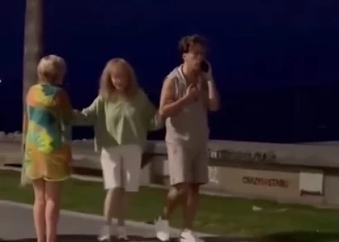 На видео видно, как пара идет вдоль моря и встречает своих поклонников.