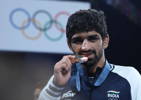 Amans Sehravats pozē Parīzes olimpisko spēļu medaļu ceremonijā.