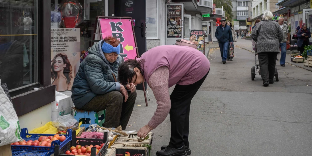 Cilvēki Čuhuivā, Ukrainas austrumos. 2025. gada 8. oktobris.