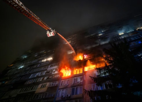 Сотрудники экстренных служб тушат пожар после российской атаки в Киеве.