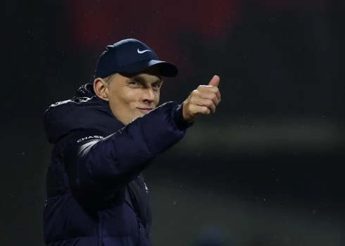 Anglijas treneris Tomass Tuhels ar smaidu reaģē uz fanu dziesmām viņa virzienā.