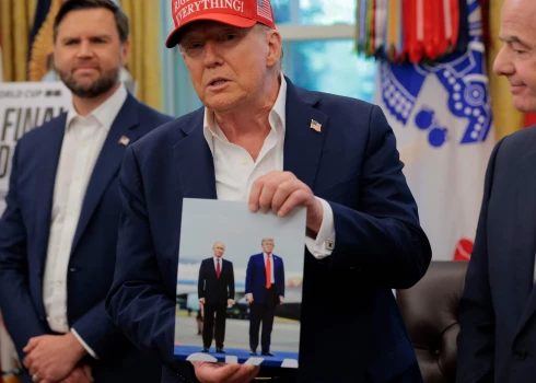 Президент США Дональд Трамп держит фотографию, на которой он запечатлён вместе с президентом России Владимиром Путиным на Аляске, в Овальном кабинете 22 августа 2025 года в Вашингтоне.