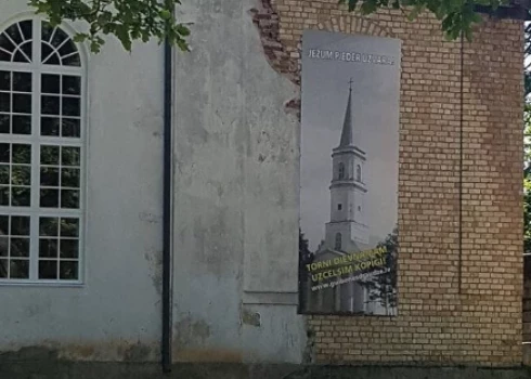 Gulbenes luterāņu baznīca ar plakātu, kurā attēlots baznīcas tornis (foto: lelbgulbenesdraudze.lv)