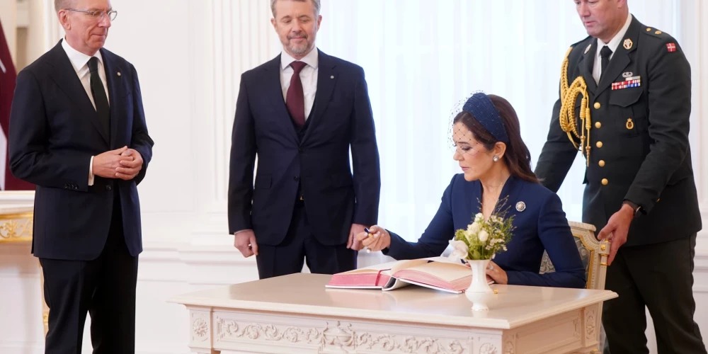 Dānijas karaliene Mērija veic ierakstu Rīgas pils viesu grāmatā, klātesot Latvijas Valsts prezidentam Edgaram Rinkēvičam un Dānijas karalim Frederikam X Rīgas pilī.