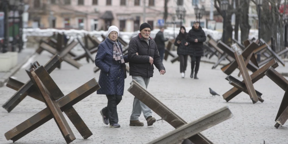 Местные жители между противотанковыми «ежами» в Одессе, Украина, 16 марта 2022 года.