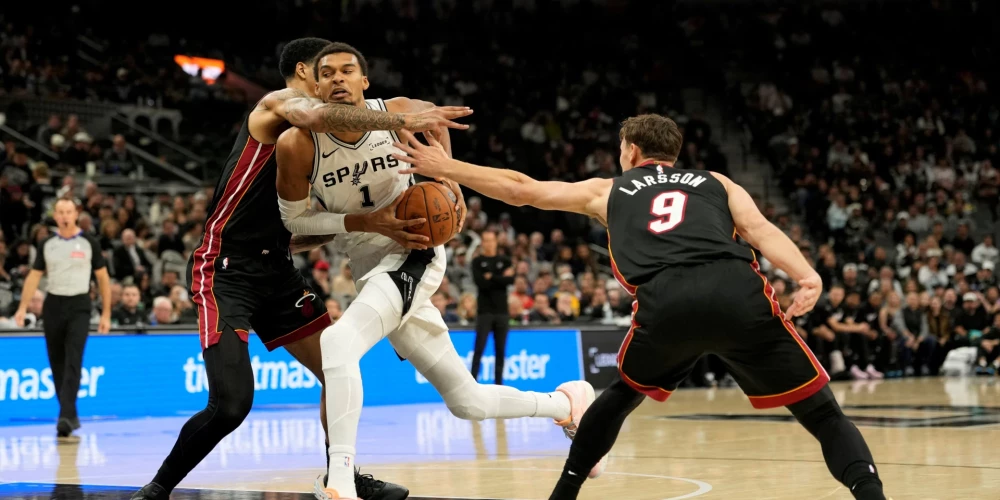 "Heat" basketbolisti Kelels Vērs un Pelle Larsons divatā cenšas kavēt Viktoru Vembanjamu.