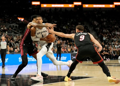 "Heat" basketbolisti Kelels Vērs un Pelle Larsons divatā cenšas kavēt Viktoru Vembanjamu.