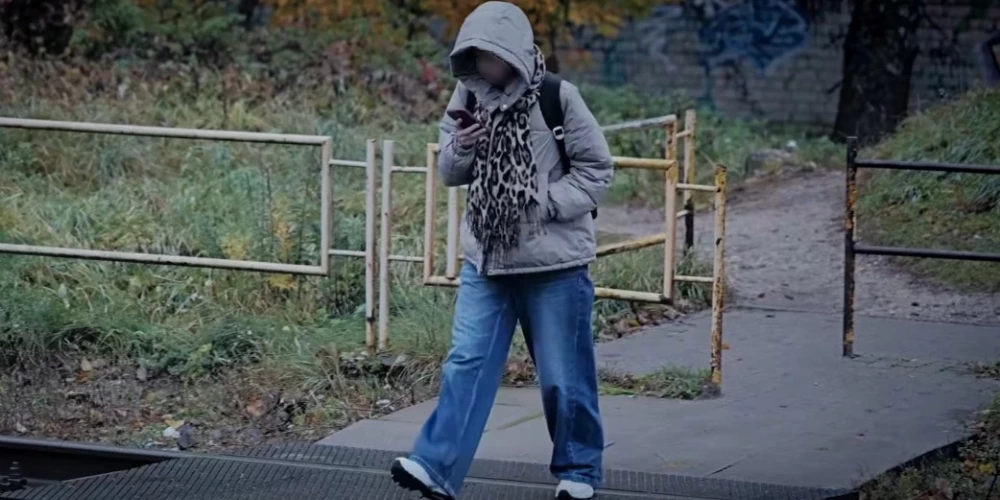 Подростки в капюшонах пересекают пути, глядя не по сторонам, а в телефон.