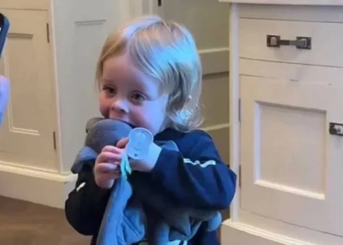 Ozija Osborna mazdēls Sidnijs cenšas nokost galvu rotaļu sikspārnim.