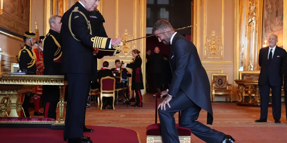 Дэвид Бекхэм преклоняет колено для посвящения в рыцари.