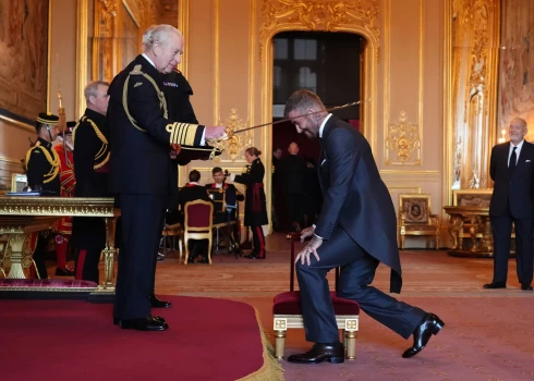 Дэвид Бекхэм преклоняет колено для посвящения в рыцари.