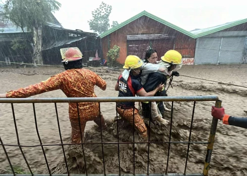 Glābēji Cebu provincē nogādā drošībā kādu ciema iedzīvotāju.