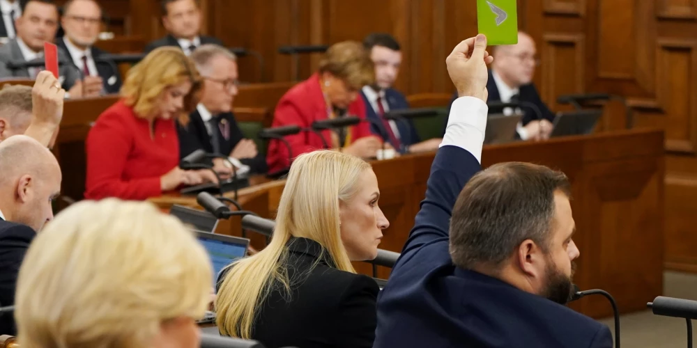 Saeimas deputāti Edmunds Jurēvics (no labās) un Agnese Krasta piedalās Saeimas ārkārtas sēdē, kurā pirmajā lasījumā sāk skatīt 2026.gada valsts budžetu un tā pavadošos likumprojektus.