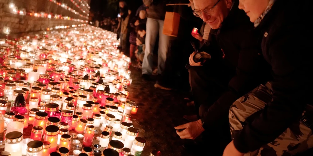 Valsts prezidents Edgars Rinkēvičs, godinot Latvijas brīvības cīnītājus, noliek svecīti 11. novembra krastmalā