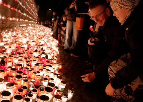 Valsts prezidents Edgars Rinkēvičs, godinot Latvijas brīvības cīnītājus, noliek svecīti 11. novembra krastmalā