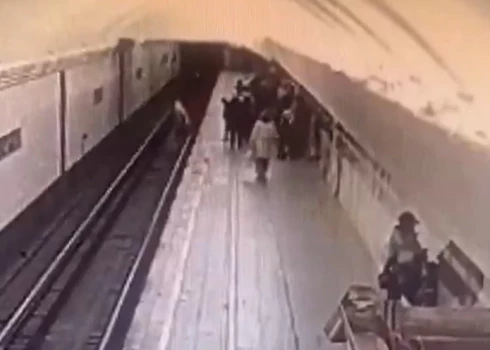 Brīdis, kad pagrūstā meitene nokrīt uz sliedēm (ekrānuzņēmums no video)